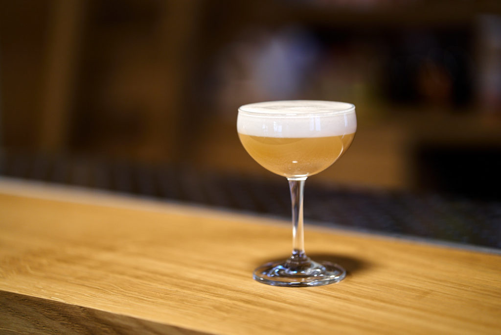 Una foto di cocktail appoggiato su un banco bar