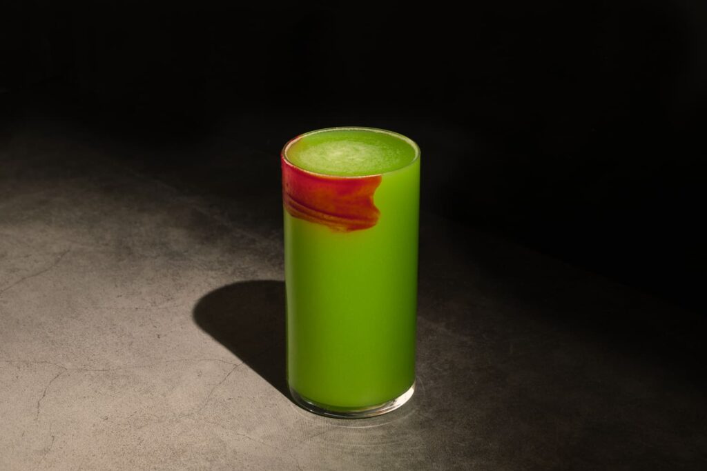 Foto di Red Eyed Frog, un cocktail verde col bicchiere verniciato di rosso